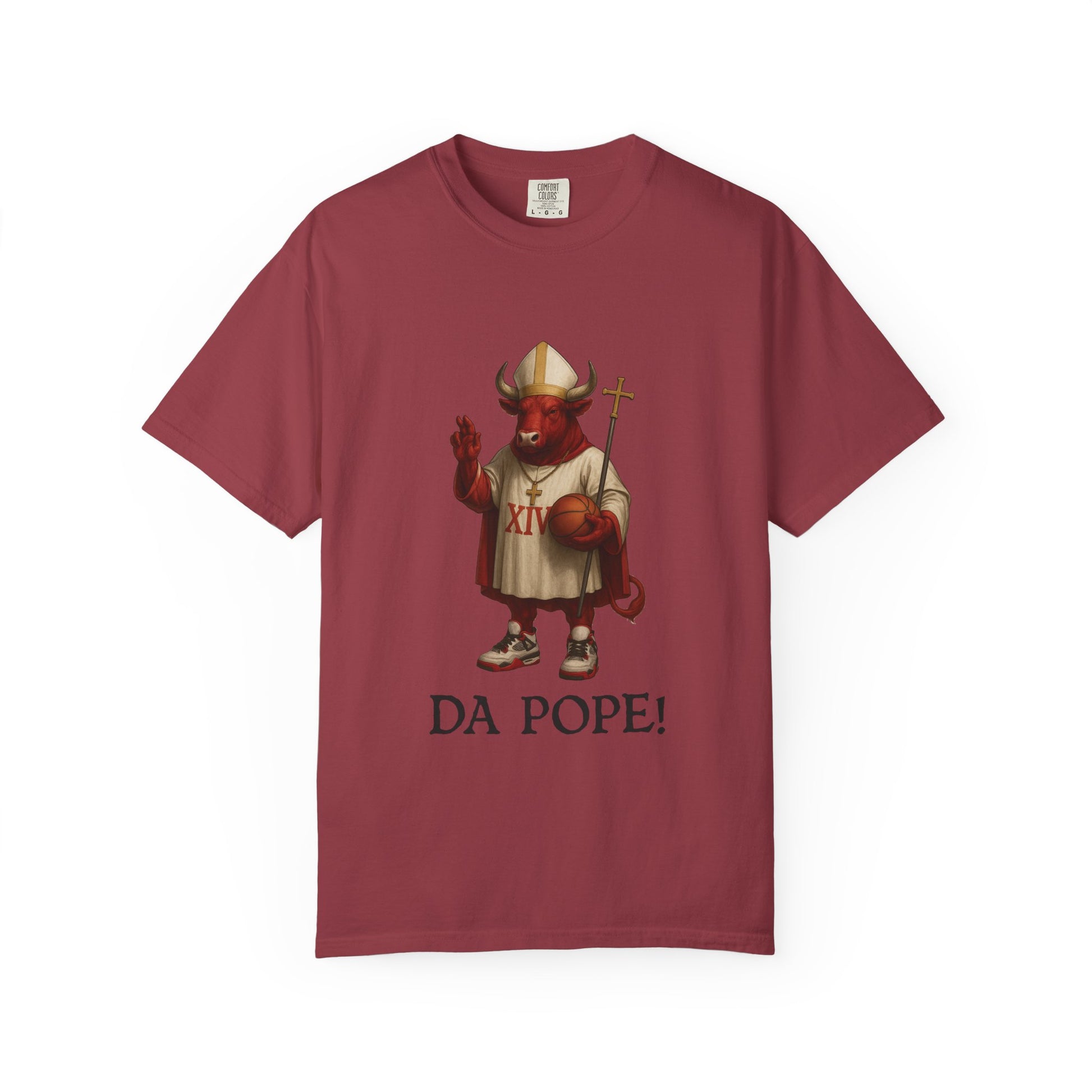 The front side of a brick colored t shirt with a design of a red Bull dressed as the pope with the saying DA POPE! below.